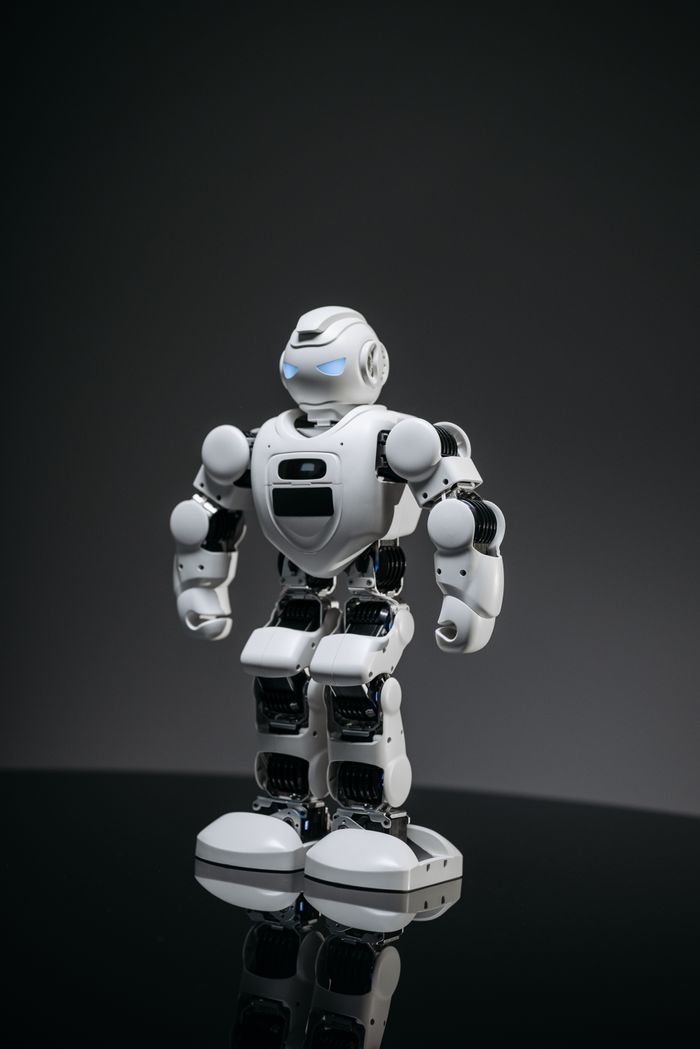 Mastering the First Impression: Your intriguing post title goes here A modern white robot with glowing blue eyes standing in a dimly lit indoor setting.