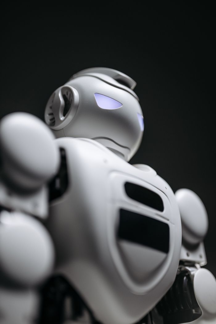 our-story Close-up of a futuristic robot with glowing blue eyes, showcasing advanced technology and design.
