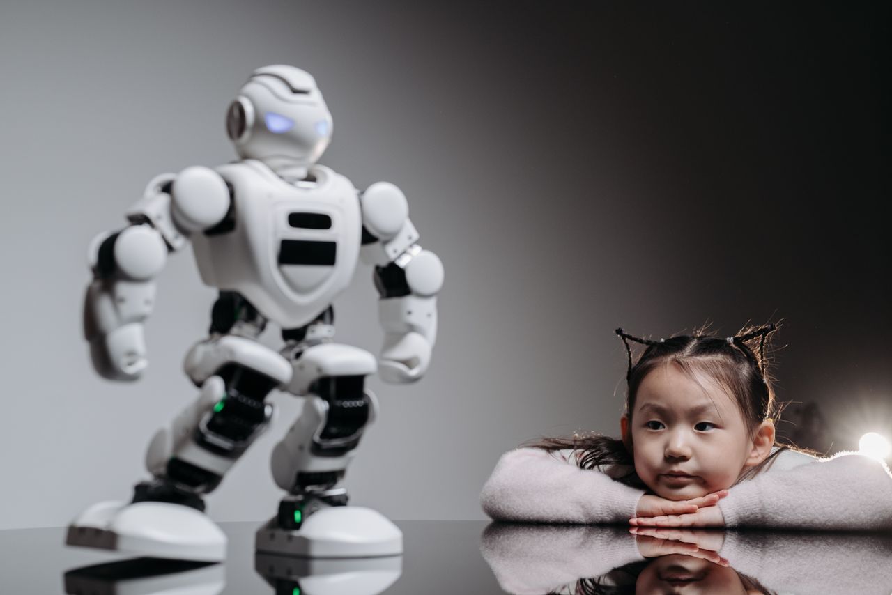 Crafting Captivating Headlines: Your awesome post title goes here An intrigued child watches a humanoid robotic toy indoors, symbolizing playful tech curiosity.